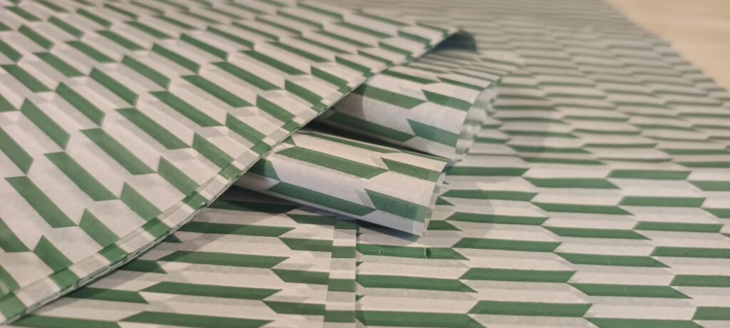 Pliego de papel seda óptico verde con diseño geométrico para packaging